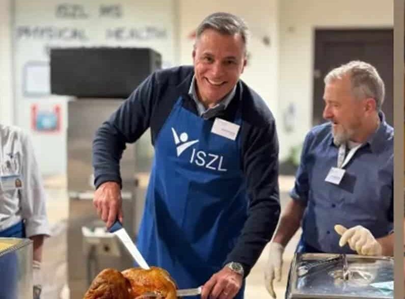 ISZL Director serving food at a festival station, engaging with the community during the 2024 Community Festival.