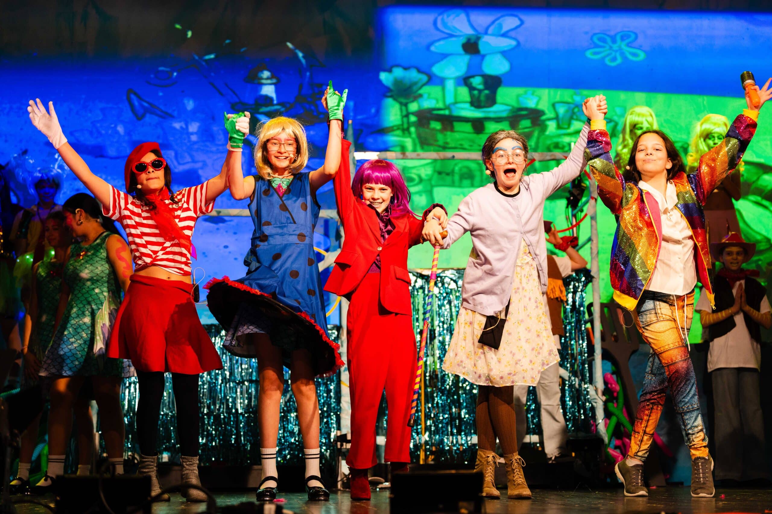 Middle School student bowing on stage after a school musical performance.
