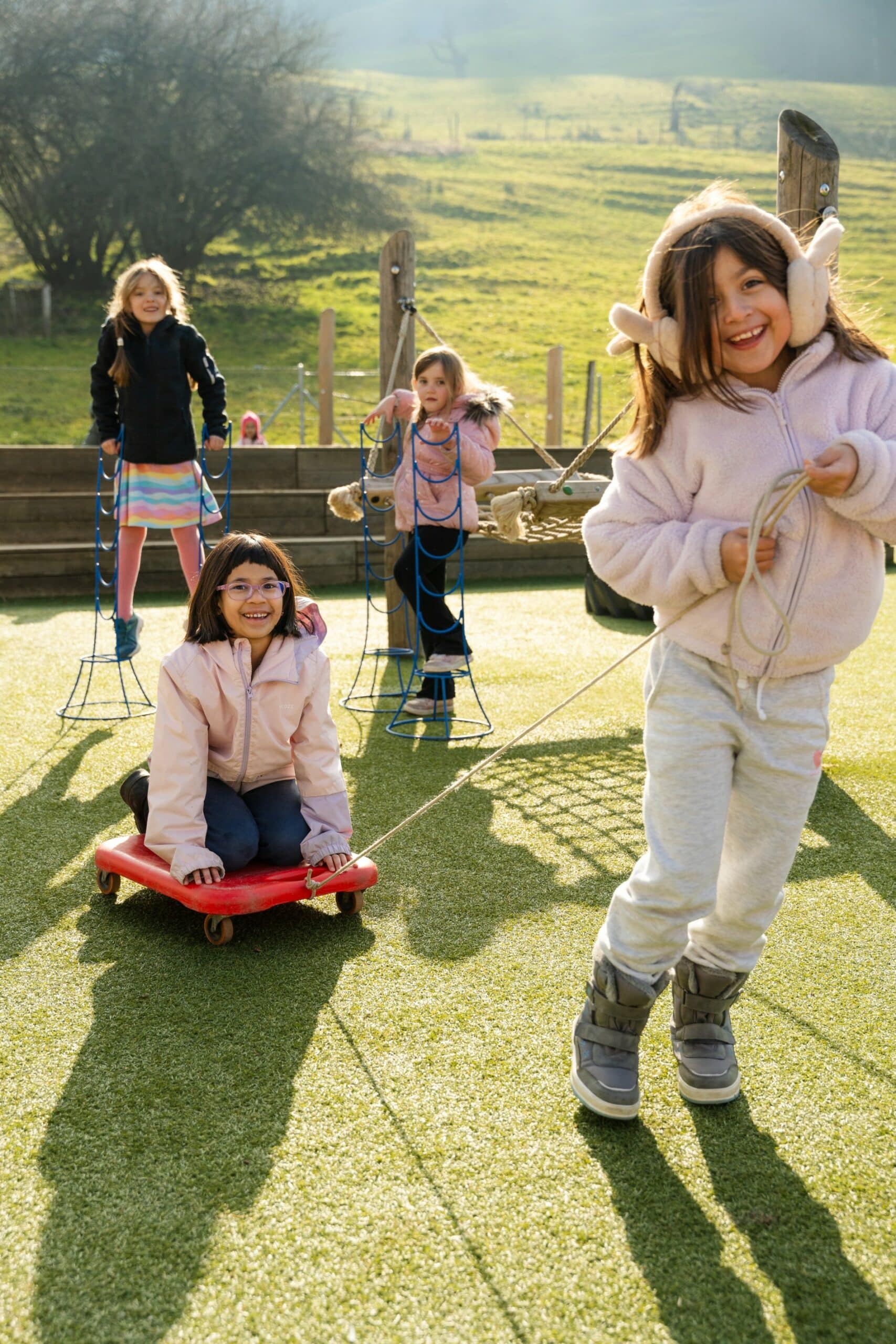 young students playing on the zug campus grass
