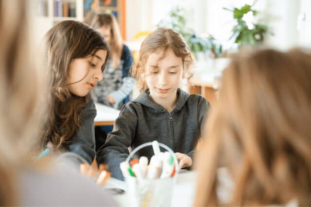 Two students working together at a table, representing ISZL’s commitment to excellence as an accredited IB World School.
