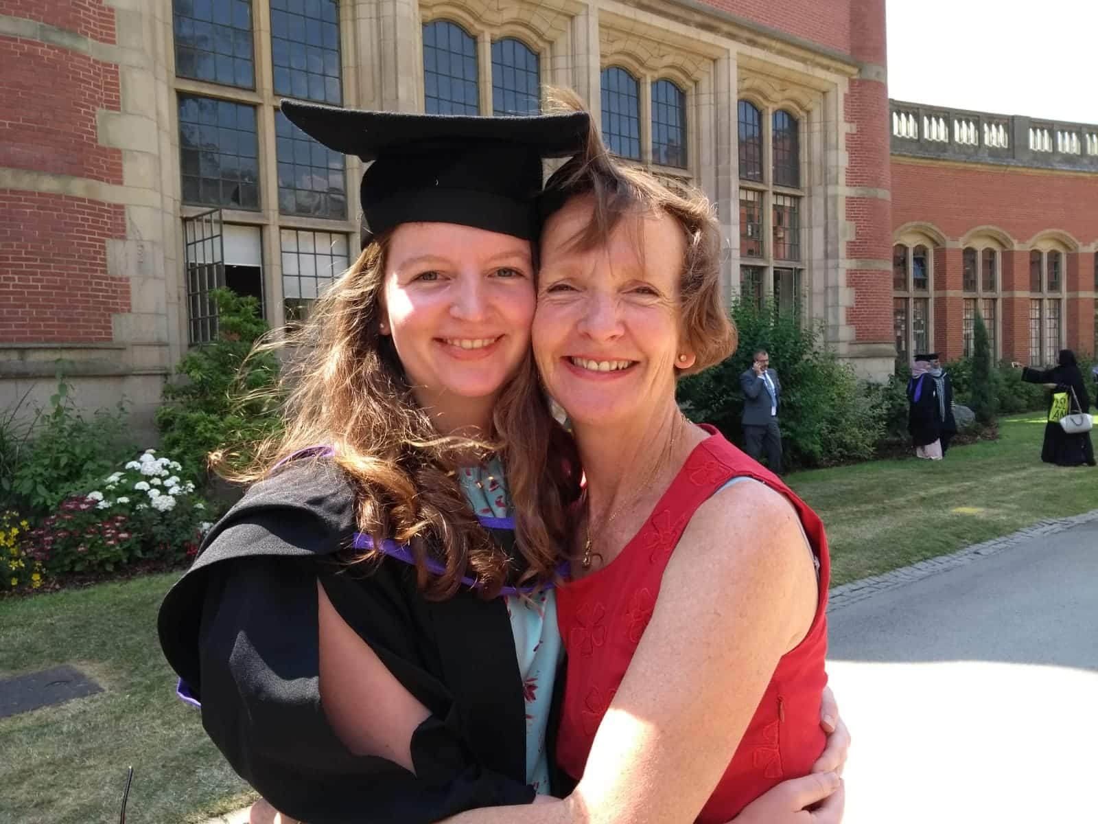 Eleanor Peel celebrating her university graduation as her mother embraces her in congratulation.