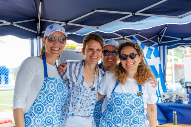 ISZL Parents’ Association members at the Greek stand during a school event, celebrating community and cultural diversity.