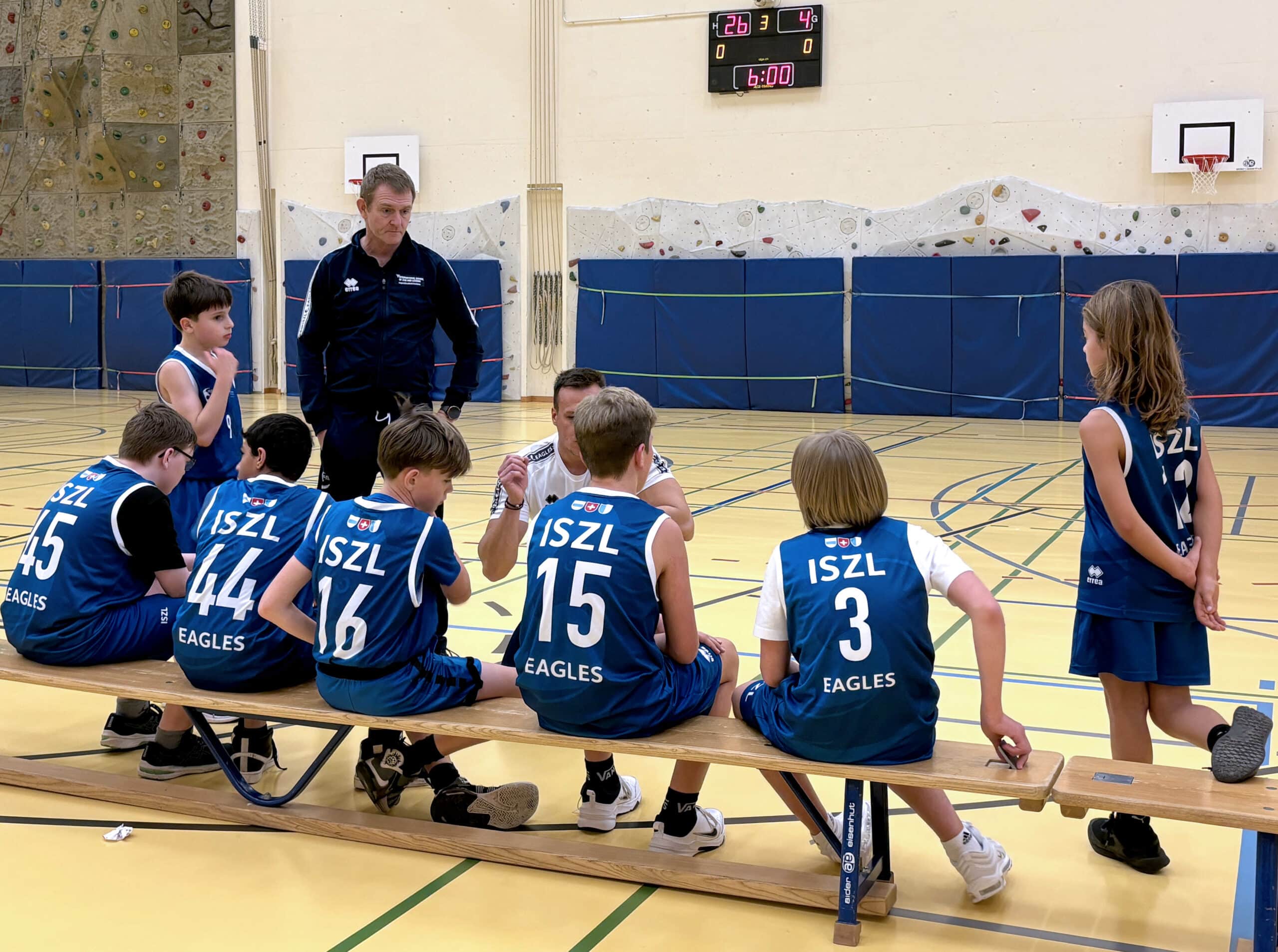 Primary school student talking with the basketball coach during training.