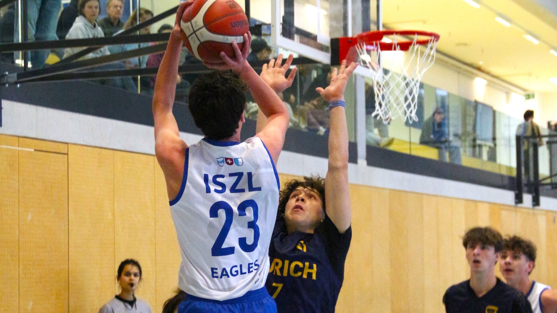 ISZL basketball team in action, making a score and demonstrating skill and teamwork on the court.