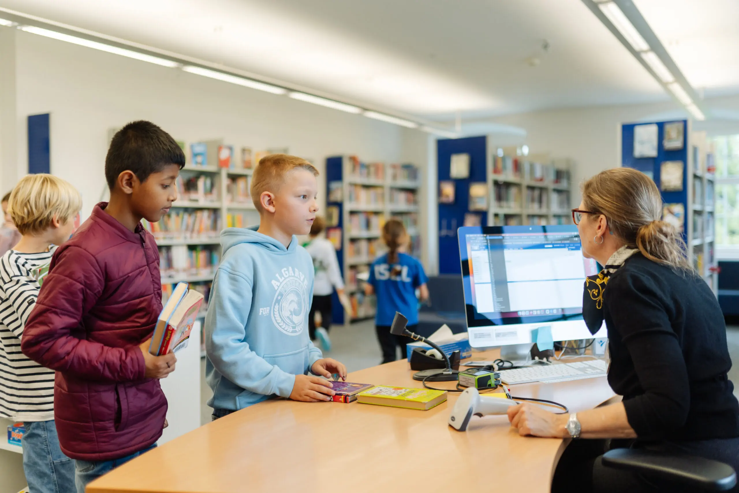 Two students in the ISZL library selecting books to read.