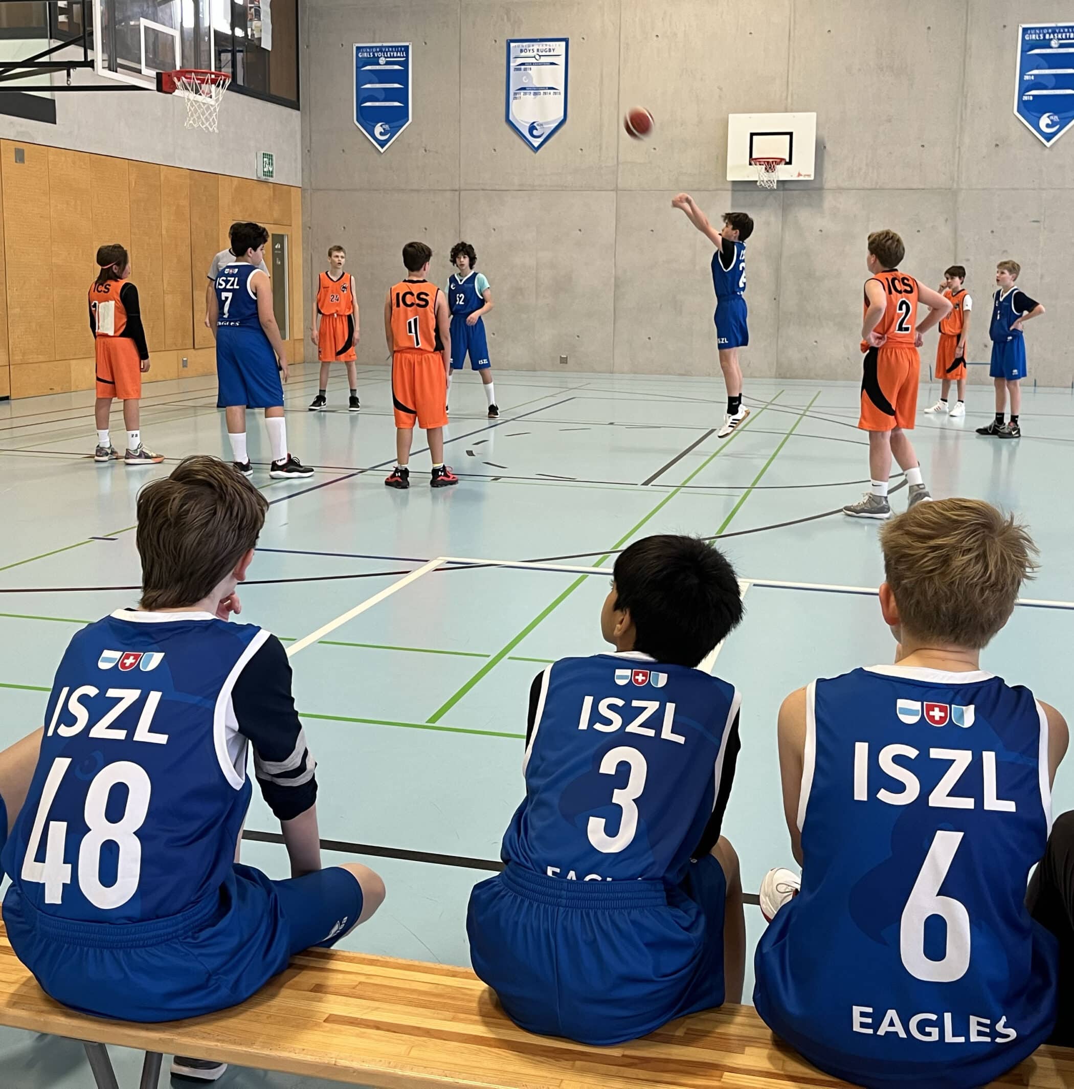 ISZL Primary school students playing basketball while other groups watch