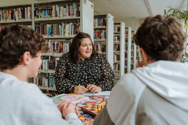 ISZL Deputy Director and student meeting in the library for discussion.