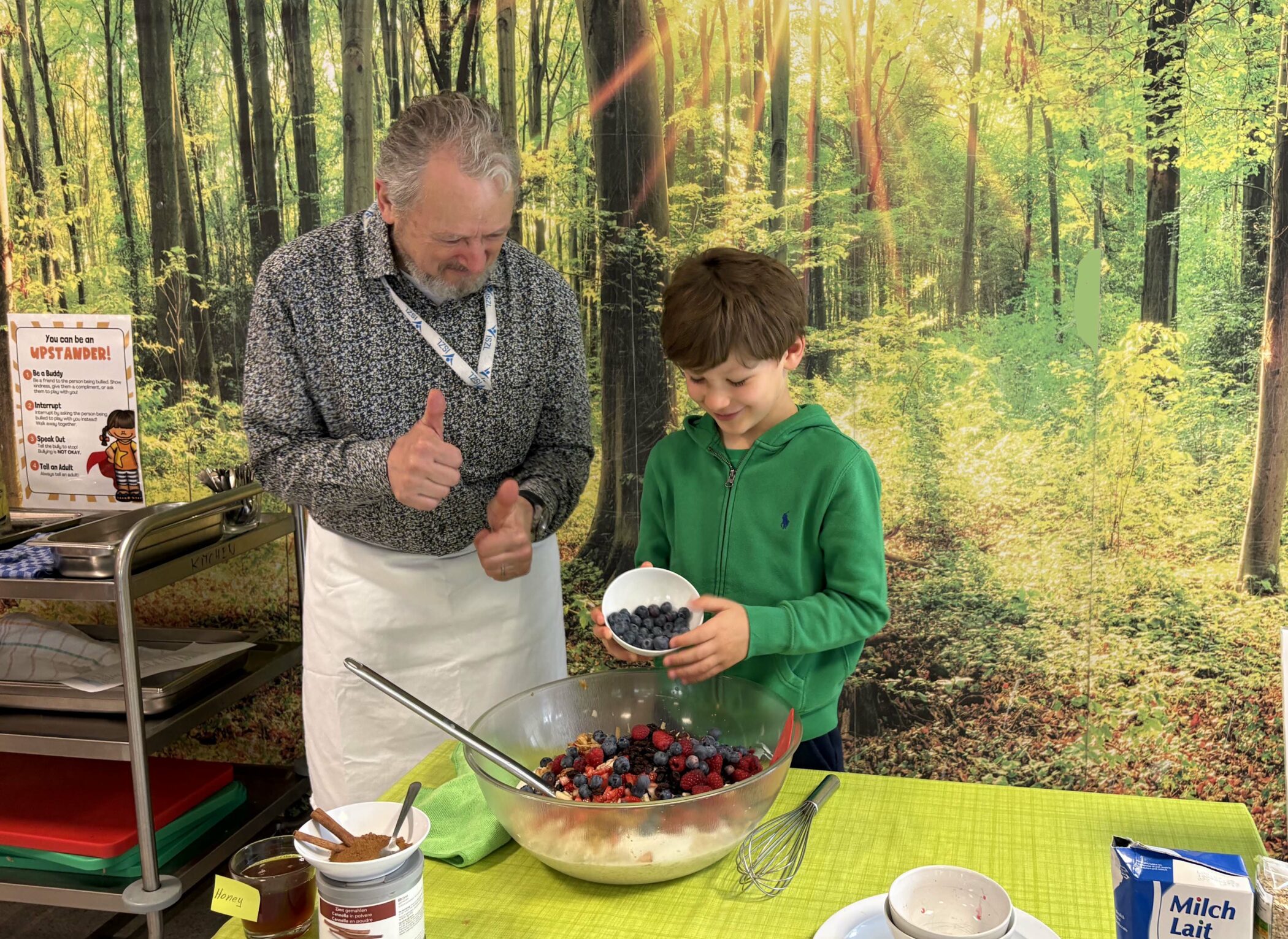 Kindergarten students mixing ingredients in bowls with the head of food