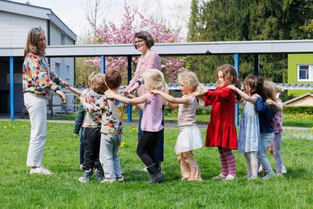 primary students on the grass with teachers