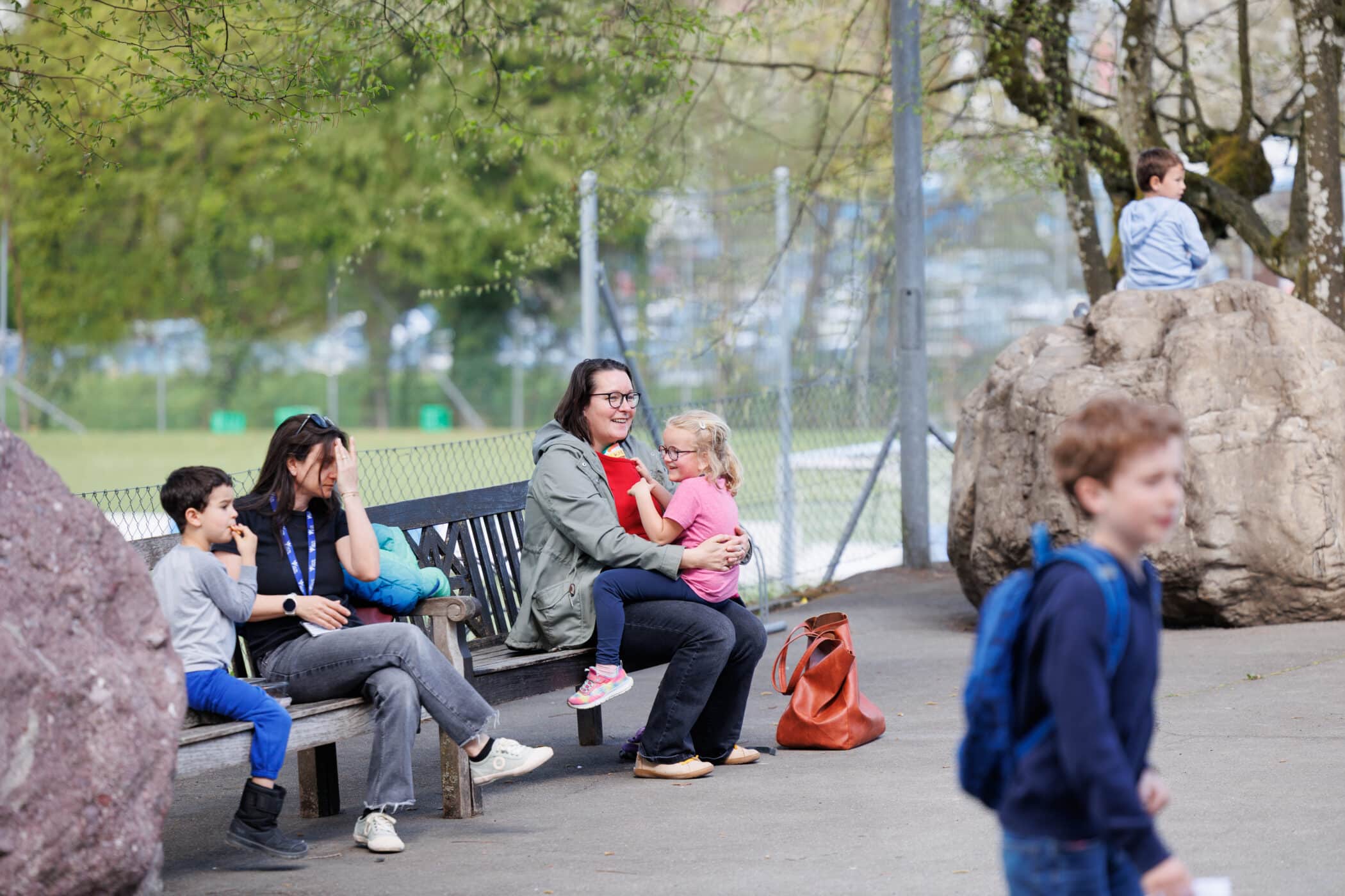 parents sitting down on bench in the sun