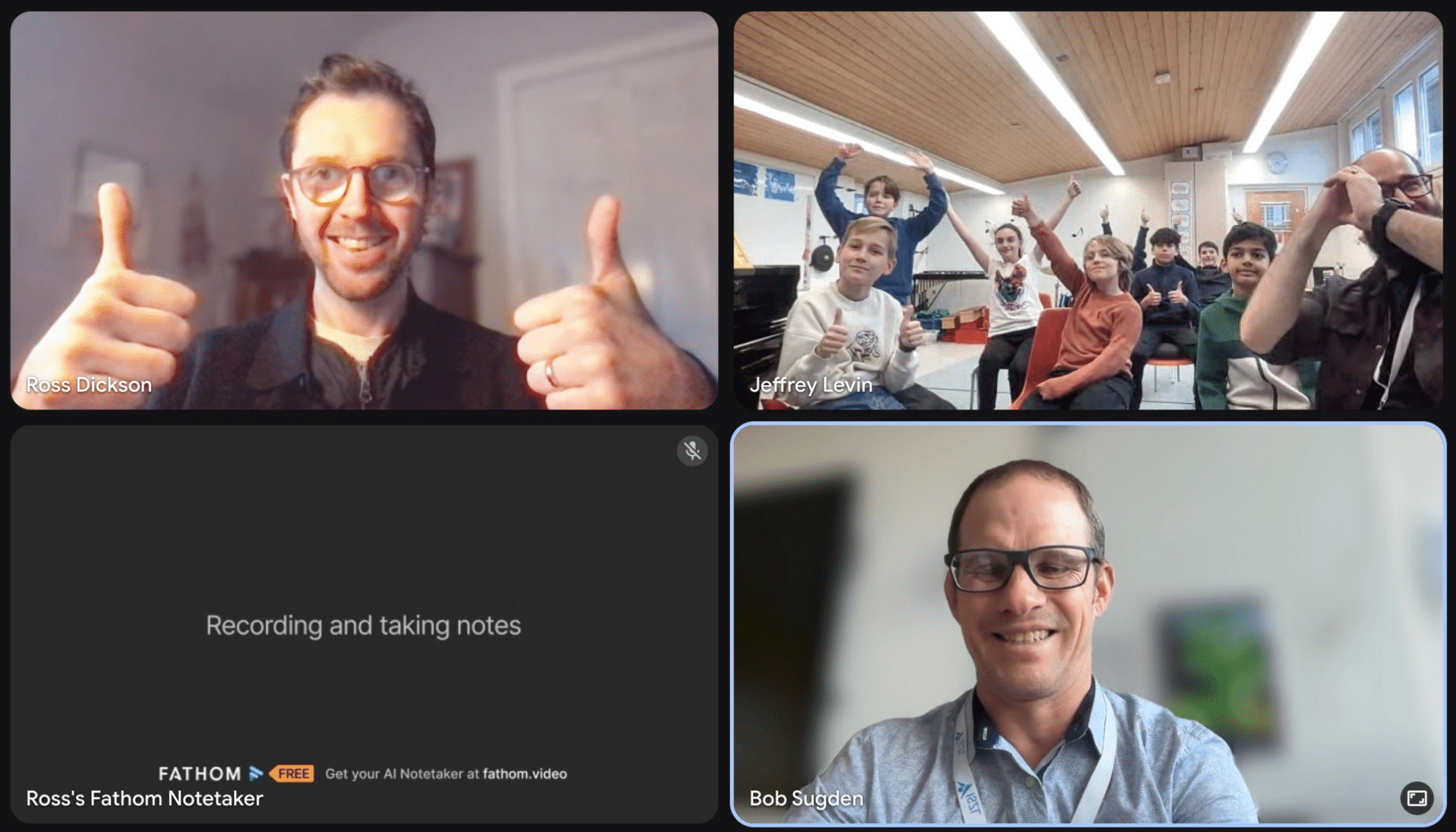A video call screen showing four participants: a man giving a thumbs up, a group of students in a classroom raising their hands, a note-taking screen, and another man smiling on camera.
