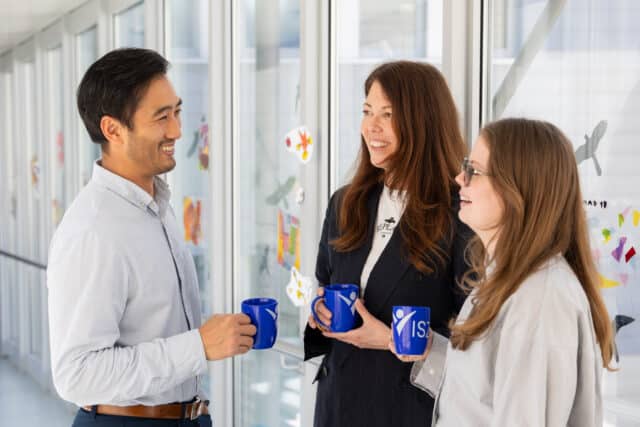 admissions staff chatting with coffee cups