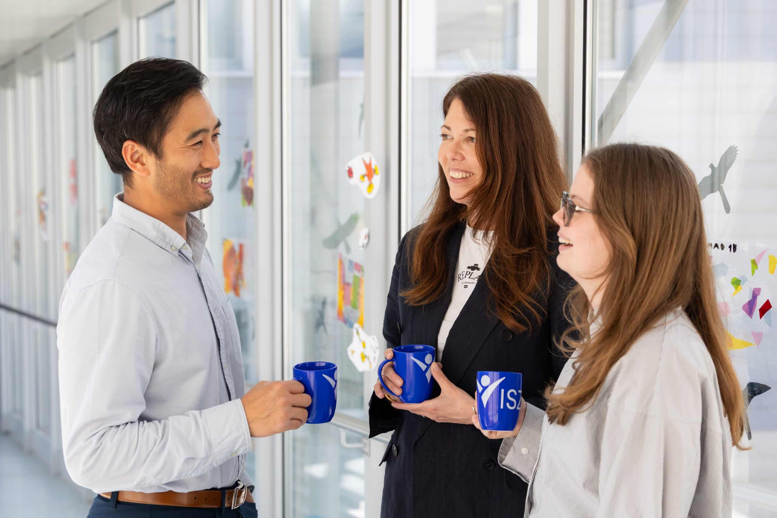 admissions staff chatting with coffee cups