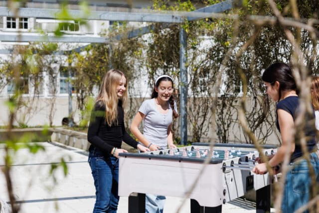 middle school students playing fussball outdoors