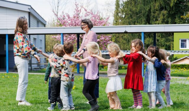 two educators teaching primary school students outdoors